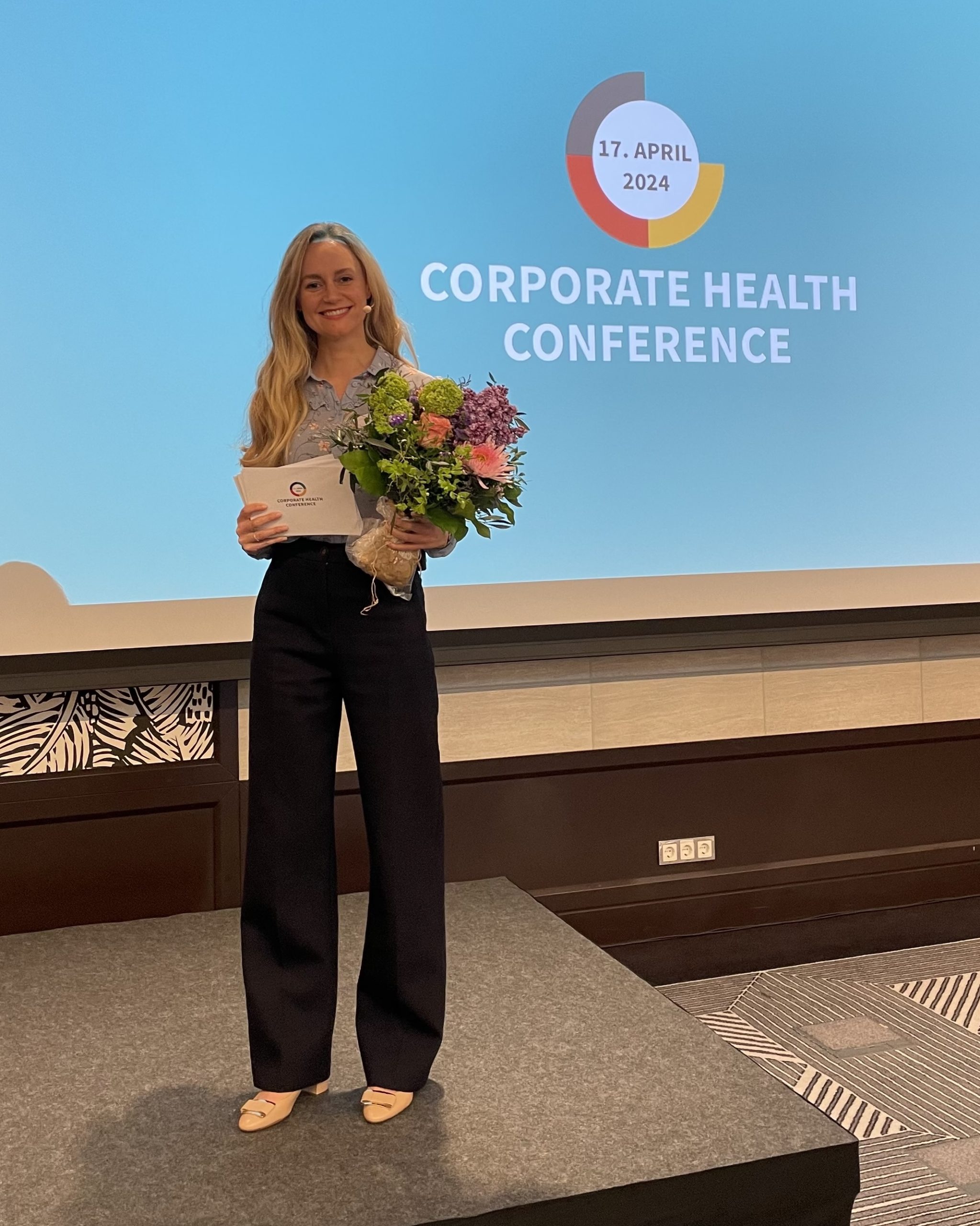Moderatorin Janina Treis, aus Stuttgart, führt durch die Corporate Health Conference in Frankfurt.